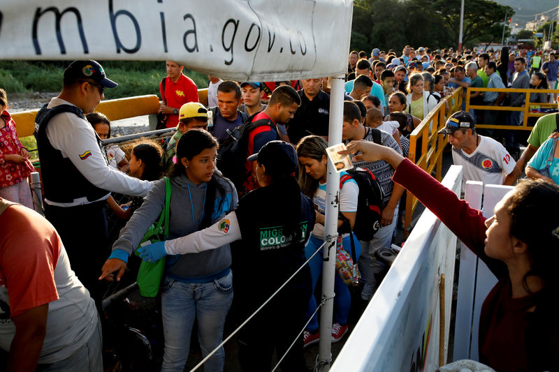© Reuters. Funcionarios de migración de Colombia revisan los documentos de personas que tratan de entrar desde Venezuela, en el puente internacional Simón Bolívar en Villa del Rosario. Imagen de archivo.