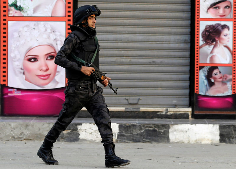 © Reuters. Un miembro de las fuerzas especiales policiales egipcias vigila la entrada de la iglesia del Gran Mártir Príncipe Tadros en Minya, Egipto.