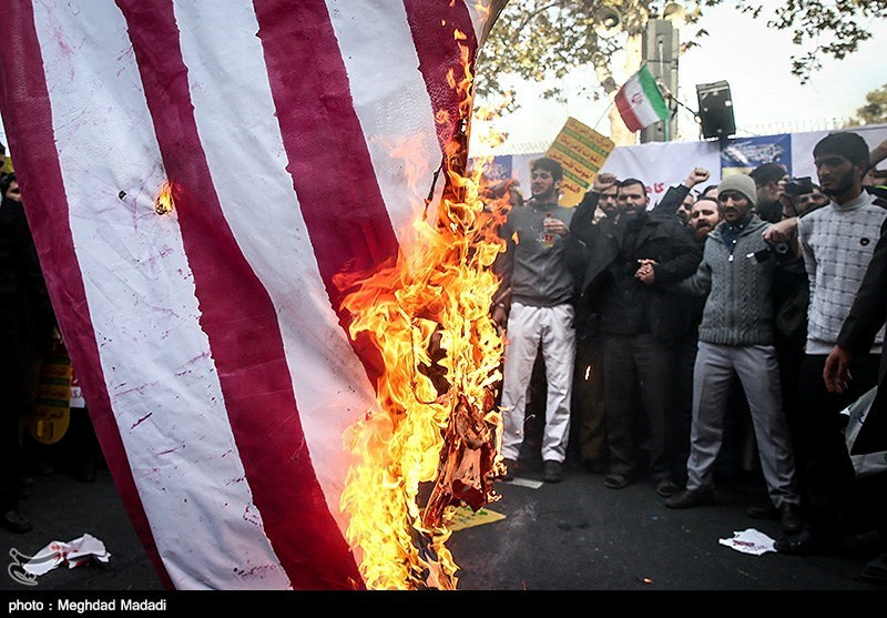 © Reuters. Un grupo de iraníes quema una bandera estadounidense en el aniversario del asalto a la Embajada de Estados Unidos en Teherán, Irán.