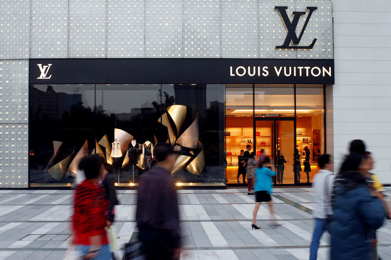 © Reuters. FILE PHOTO Pedestrians pass in front of a Louis Vuitton shop in Chengdu, Sichuan province, in China