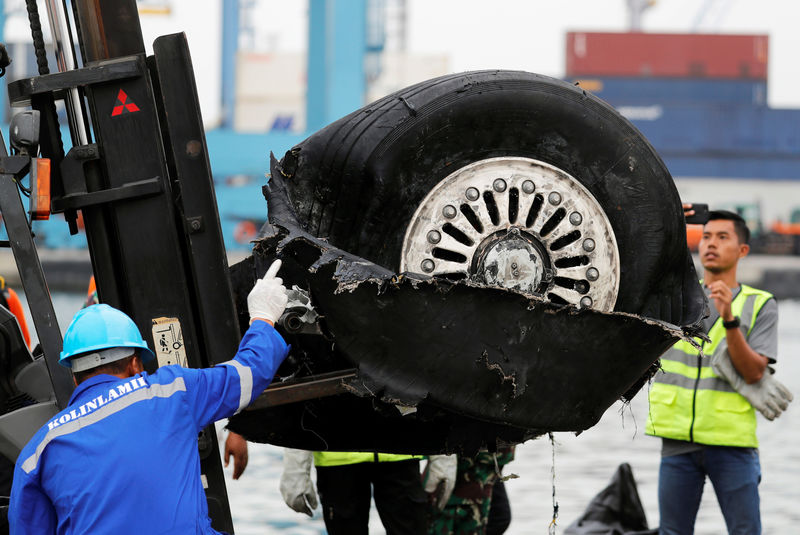 © Reuters. Roda de avião que caiu no mar na Indonésia é transportada por funcionários em porto de Jacarta