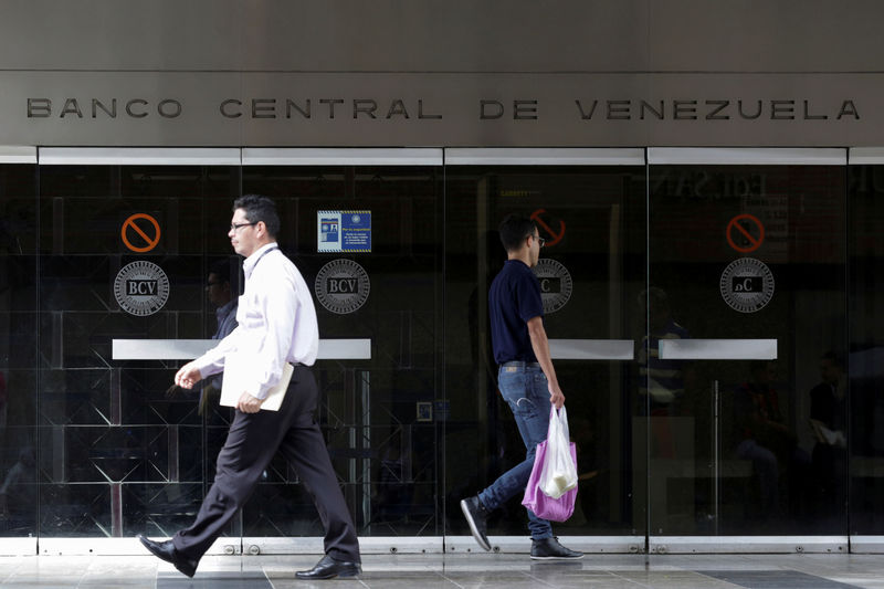 © Reuters. FILE PHOTO: People walk past an entrance of the Venezuela's Central Bank in Caracas