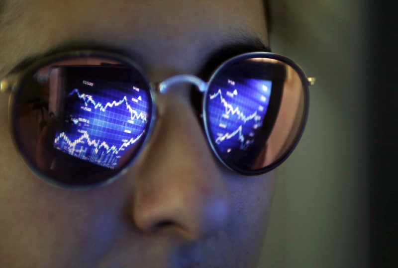 © Reuters. A computer screen showing stock graphs is reflected on glasses in this illustration photo taken in Bordeaux