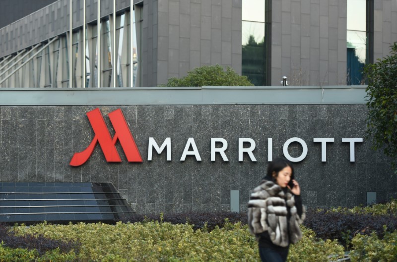 © Reuters. FILE PHOTO - Woman on a mobile phone walks past a Marriott hotel in Hangzhou