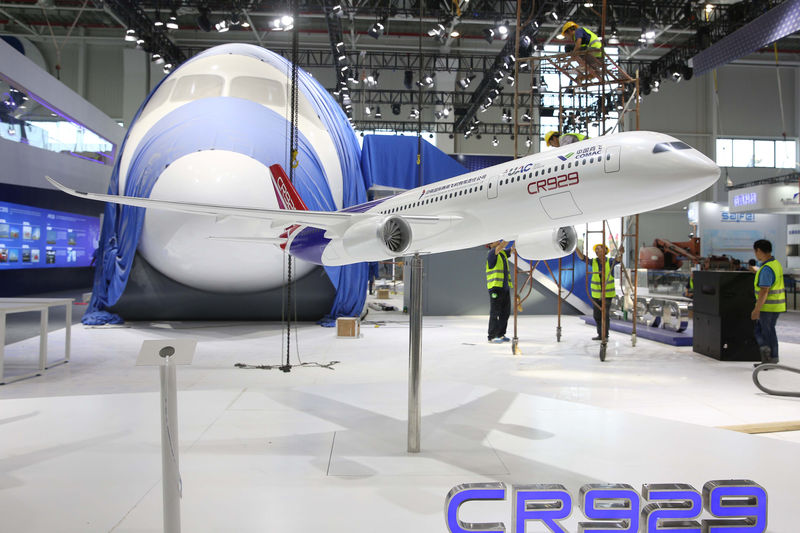 © Reuters. Workers are seen next to a model of CR929 at a booth ahead of the Zhuhai Airshow