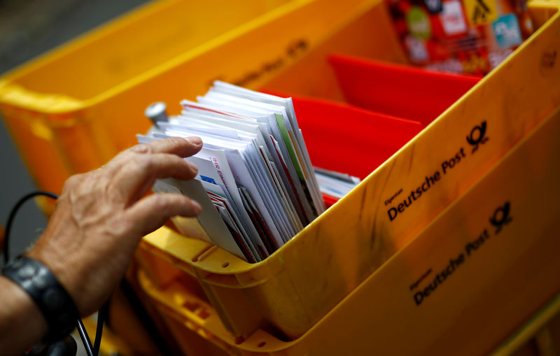 © Reuters. FILE PHOTO: A postman of German mail services Deutsche Post AG delivers mail in Hanau