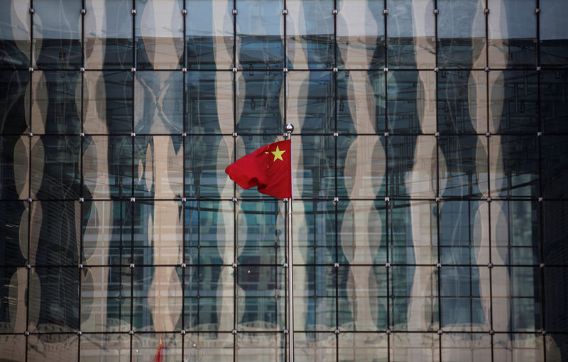 © Reuters. FILE PHOTO: Chinese national flag flutters at the headquarters of a commercial bank on a financial street near the headquarters of the People's Bank of China, China's central bank, in central Beijing