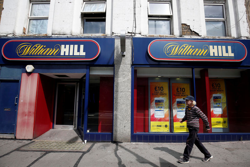 © Reuters. FILE PHOTO: A pedestrian walks past a William Hill betting shop in London