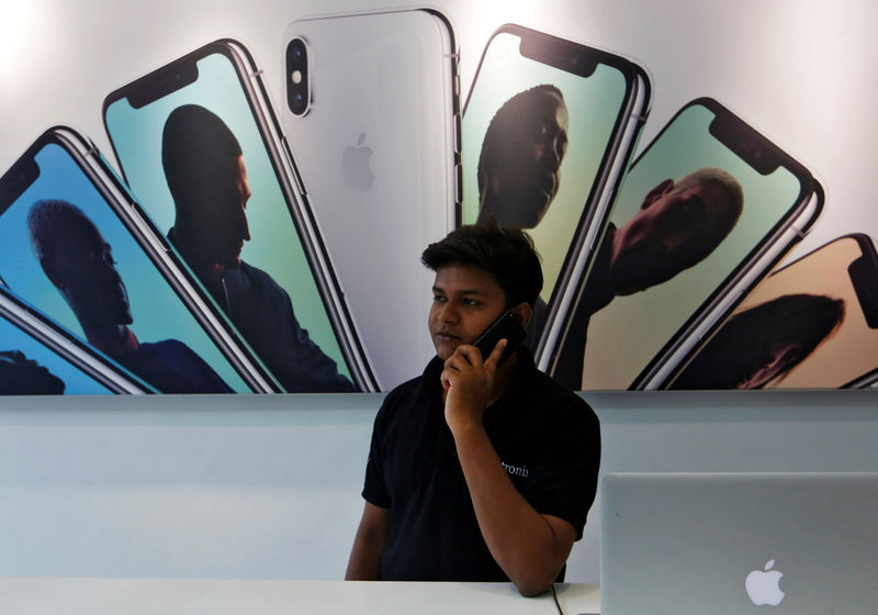 © Reuters. FILE PHOTO: Salesperson speaks on the phone at an Apple reseller store in Mumbai