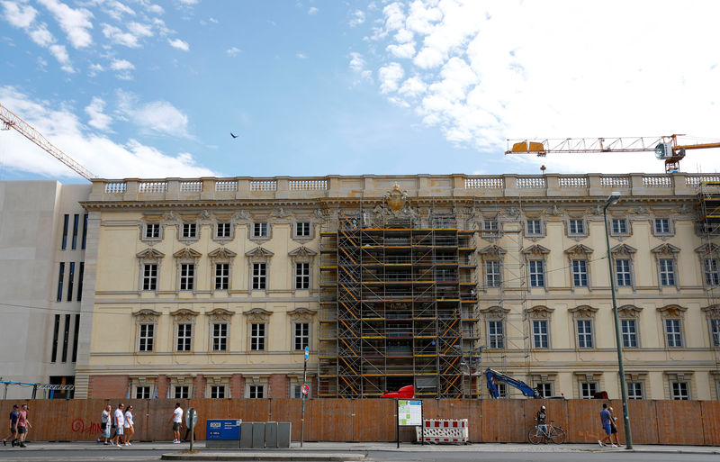 © Reuters. Workers are seen at the partially scaffolded new facade at construction site of the Berliner Schloss (Berlin City Palace) in Berlin