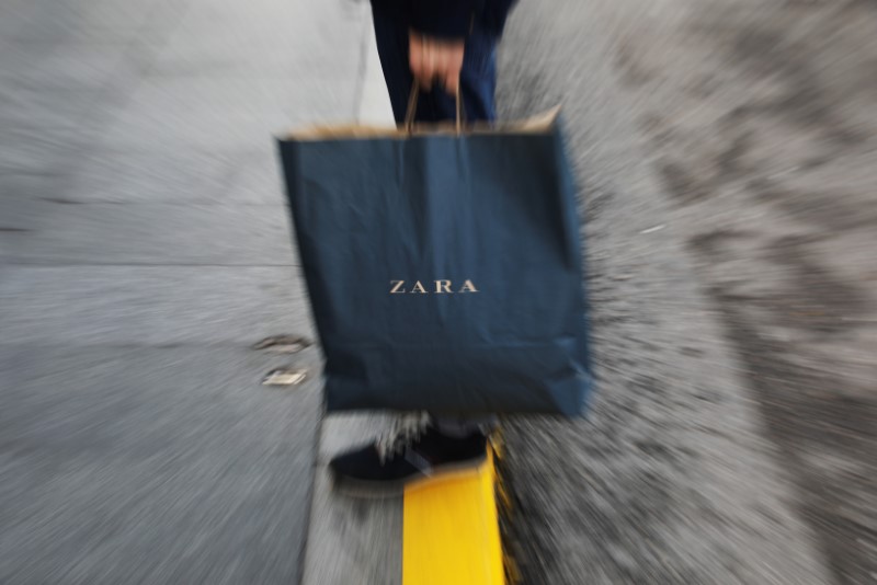 © Reuters. A mans hold a Zara shopping bag outside a Zara store, an Inditex brand, in central Madrid