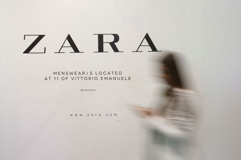 © Reuters. Una mujer delante de un anuncio de una tienda de Zara en Milán