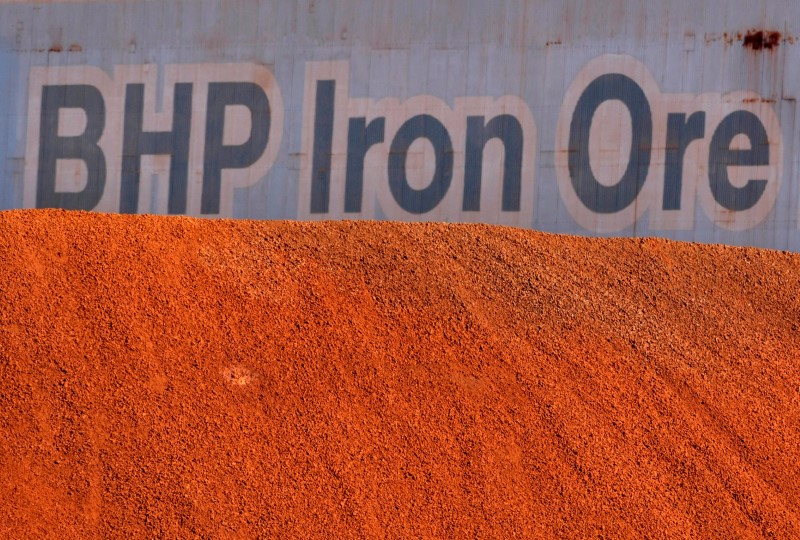 © Reuters. Placa da BHP Billiton atrás de pilha de minério de ferro na unidade de carregamento da empresa no Porto de Hedland, Austrália