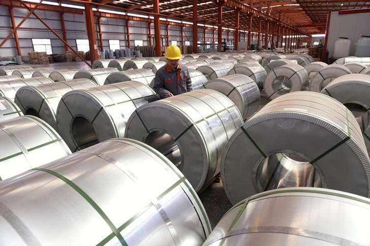 © Reuters. FILE PHOTO - A worker checks aluminium rolls at a warehouse inside an industrial park in Binzhou