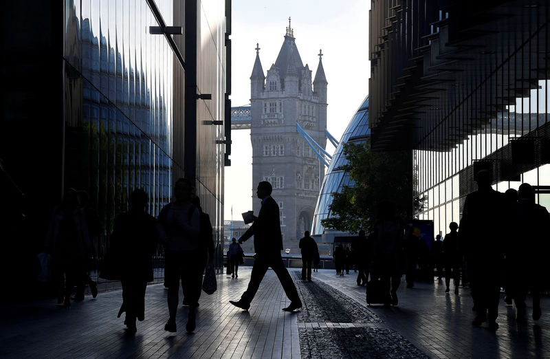 © Reuters. Workers are seen in the More London district, with Tower Bridge behind during the morning rush hour in London