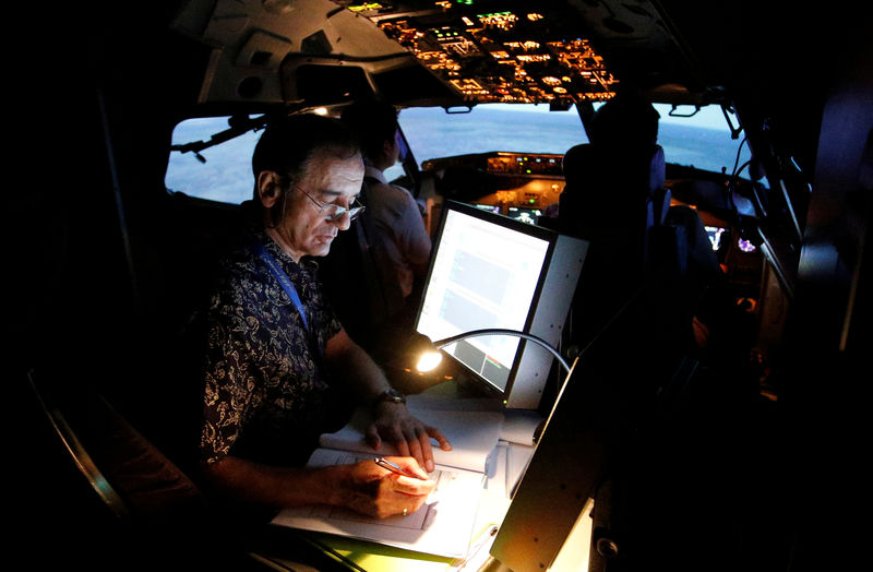 © Reuters. A senior instructor writes in a report book during a Jet Introduction session in Boeing 737-900ER simulator at Angkasa Training Center near Jakarta