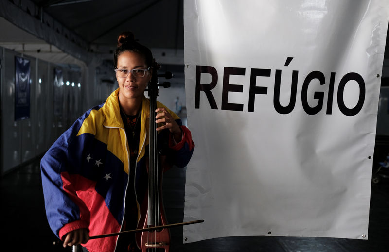 © Reuters. Venezuelana posa para foto com seu instrumento após obter status de refugiada em Pacaraima