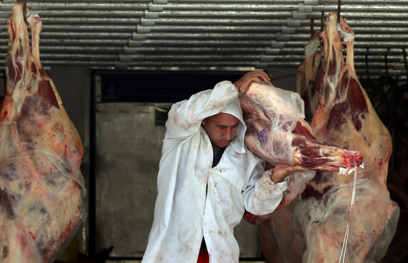 © Reuters. FILE PHOTO: A butcher unloads beef from a truck outside a butcher's shop in Sao Paulo