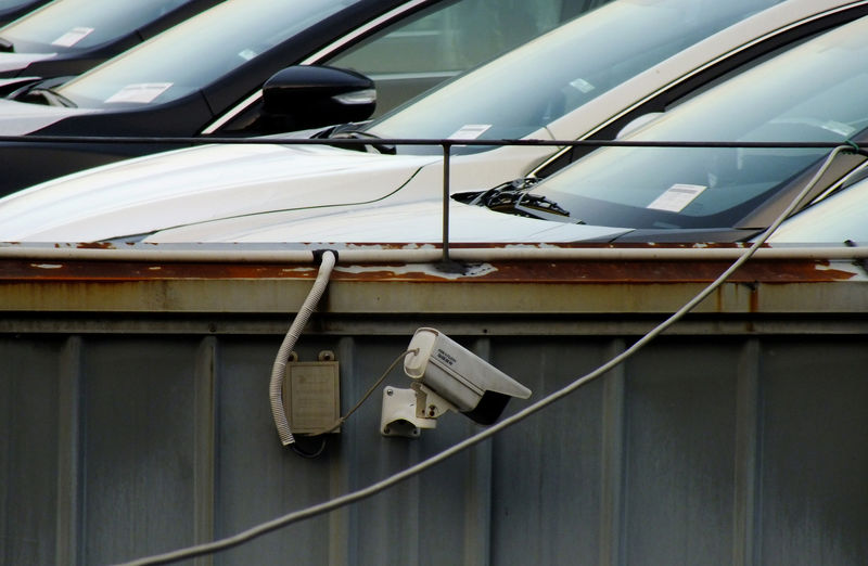 © Reuters. Surveillance camera is seen next to cars sitting on the roof of a car dealership in Yichang