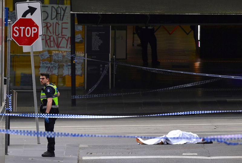 © Reuters. Policial ao lado de corpo coberto no centro de Melbourne