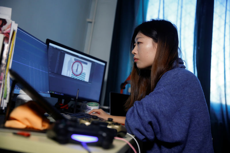 © Reuters. Game developer Wang Miaoyi works in her studio that is located in her appartment in Beijing