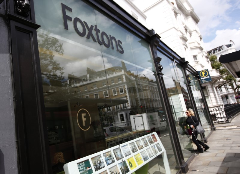 © Reuters. FILE PHOTO - A woman walks into a Foxtons estate agent in west London
