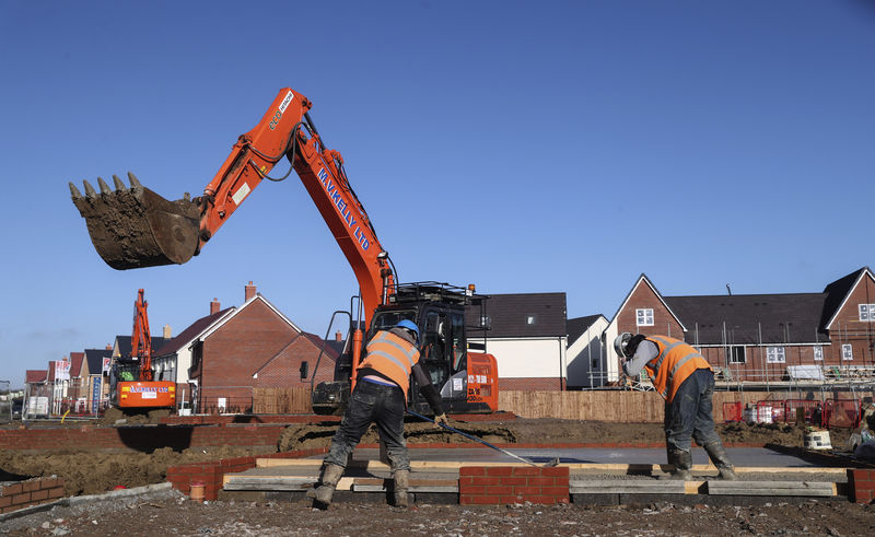 © Reuters. Construction workers work on a Taylor Wimpey housing estate in Aylesbury