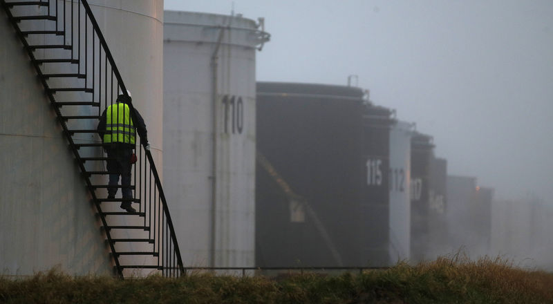 © Reuters. A worker walks down the stairs of an oil tank at the Total refinery in Grandpuits