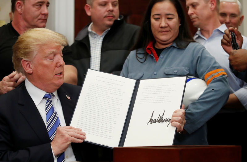 © Reuters. U.S. President Donald Trump signs a presidential proclamation placing tariffs on steel and aluminum imports while surrounded by workers from the steel and aluminum industries at the White House in Washington