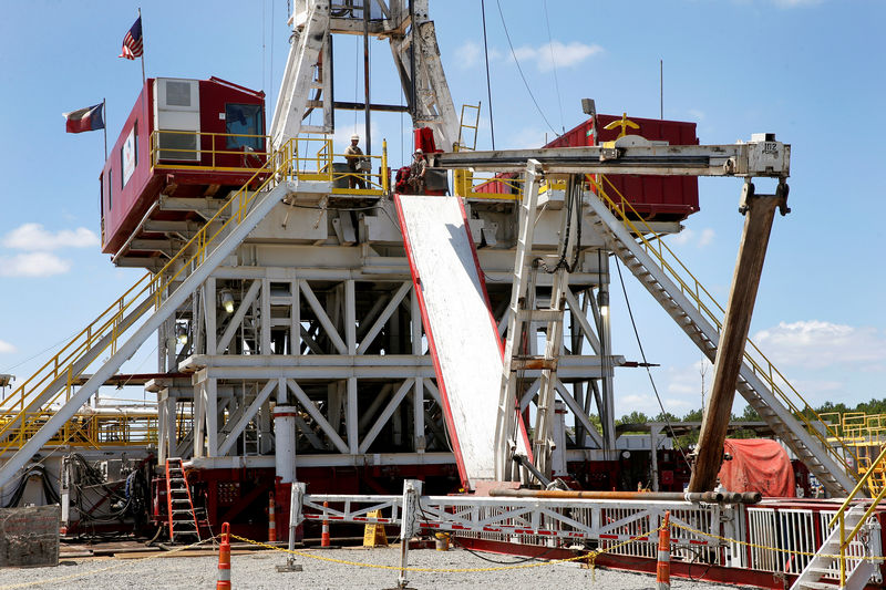 © Reuters. FILE PHOTO: Workers work on a drill rig at the BP America Dracorex Gas Unit well site in Lufkin