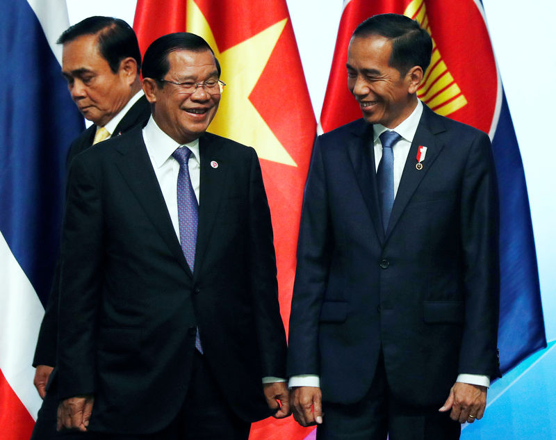 © Reuters. ASEAN leaders Indonesia's President Joko Widodo and Cambodia's Prime Minister Hun Sen chat after a group photo during the opening ceremony of the 33rd ASEAN Summit in Singapore
