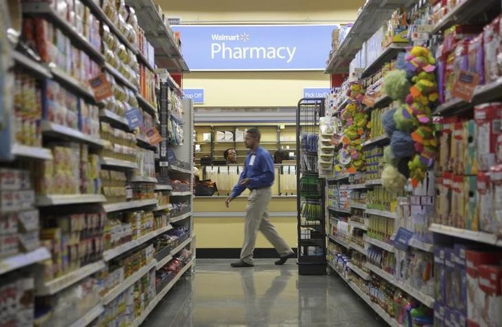 © Reuters. FILE PHOTO - A worker walks past the pharmacy in a new Walmart Express store in Chicago