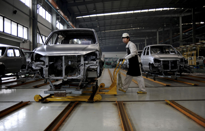© Reuters. FILE PHOTO - An employee pushes a car along a Zotye Automobile Co., Ltd assembly line in Jinhua