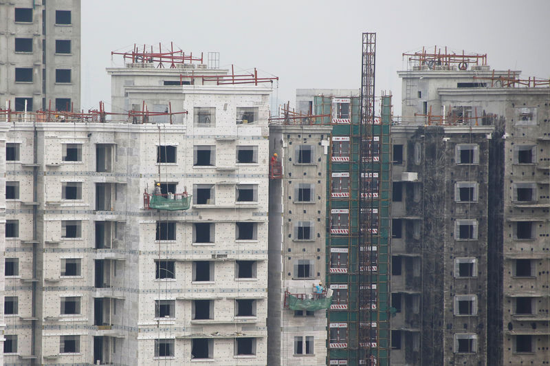 © Reuters. FILE PHOTO: Men work at a construction site of residential apartment blocks in Beijing