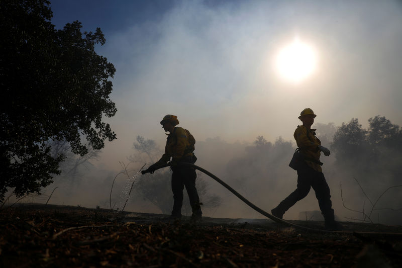 © Reuters. Bomberos combaten el fuego en Simi Valley, California