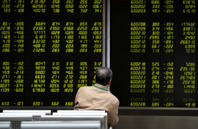 © Reuters. Инвестор у электронного табло с котировками акций в брокерской фирме в Пекине