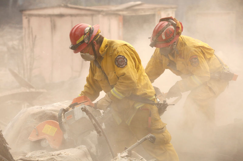 © Reuters. Bombeiros vasculham casa destruída pelo Incêndio Fire em Paradise, na Califórnia