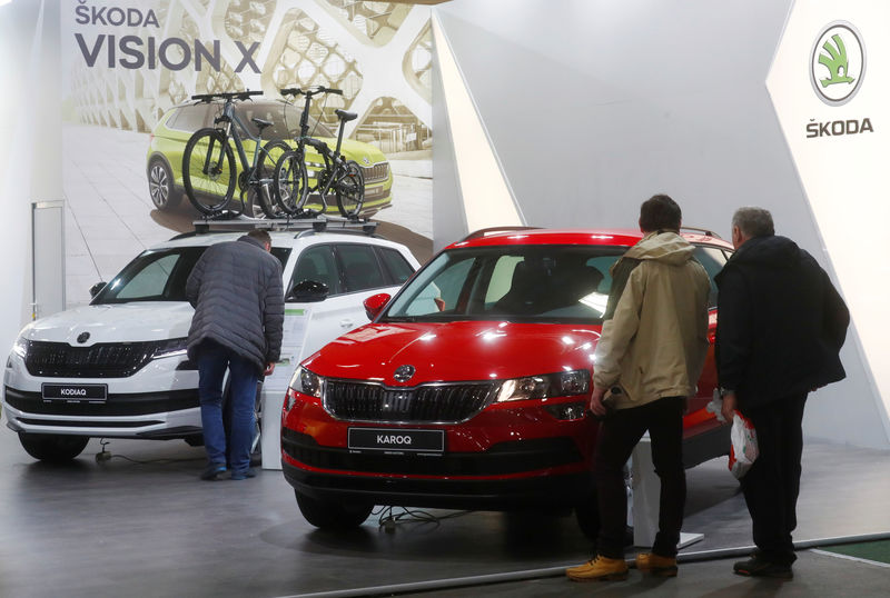 © Reuters. People look at Skoda Kodiaq and Karoq cars during the motor show in Riga