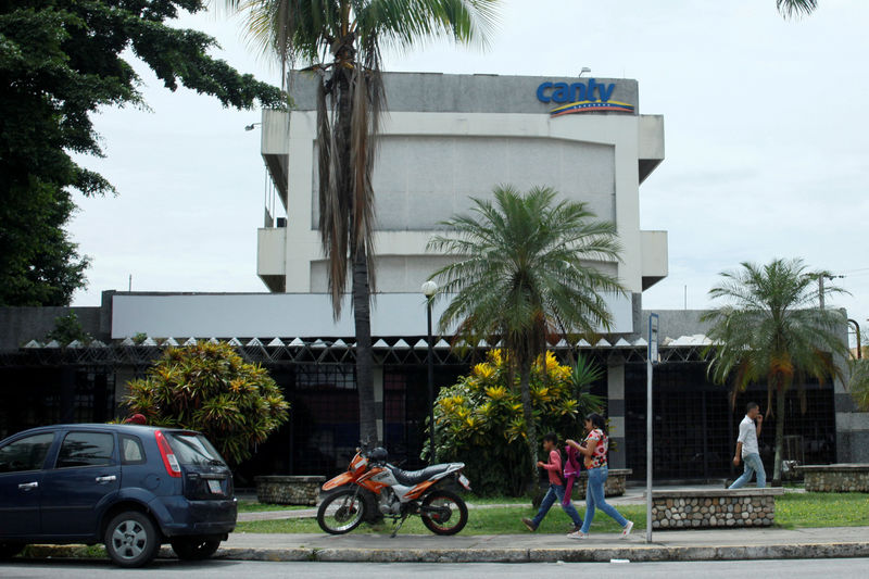 © Reuters. People walk past an office building of Venezuela's national telecommunications company CANTV in Barinas