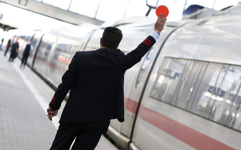 © Reuters. A Deutsche Bahn employee gestures before a train departure at the main train station in Munich