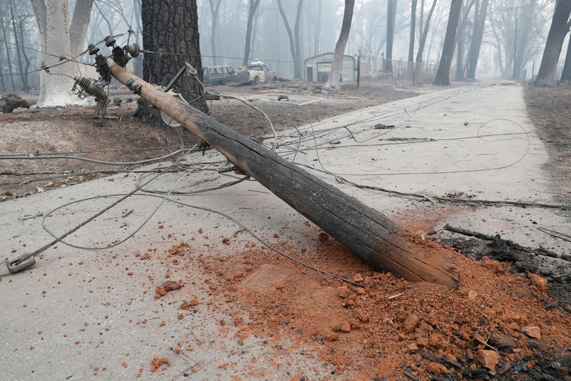 © Reuters. FILE PHOTO: Damaged power pole following the deadly Camp Fire blocks a path in Paradise