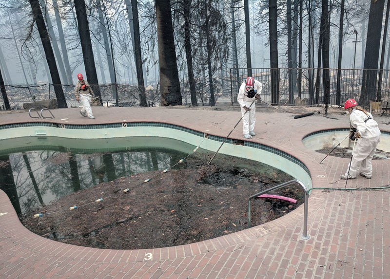 © Reuters. Investigadores forenses buscan en una piscina comunitaria por víctimas del Camp Fire en Paradise, California