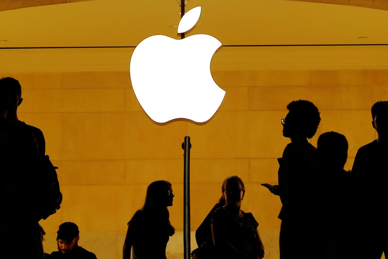 © Reuters. FILE PHOTO: Customers walk past an Apple logo inside of an Apple store at Grand Central Station in New York