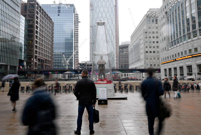 © Reuters. People walk past a temporary sculpture installed to mark the centenary of the Armistice which ended the First World War, in the Canary Wharf financial district of London