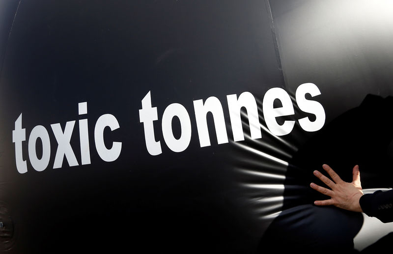 © Reuters. FILE PHOTO: Environmental activist pushes a giant ball with the words, "Toxic tonnes" during a protest outside the European Parliament in Brussels