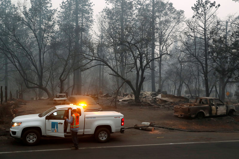 © Reuters. Employees of Pacific Gas & Electric work in the aftermath of the Camp Fire in Paradise