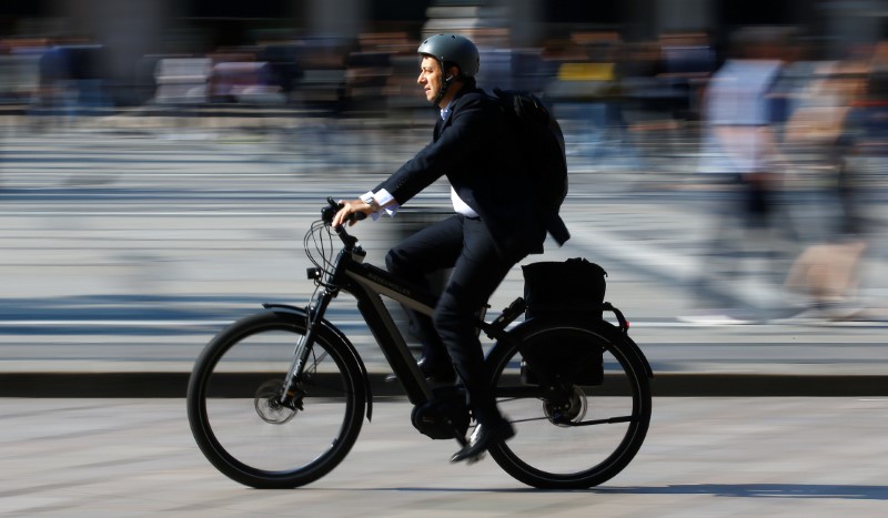 © Reuters. FILE PHOTO - A man rides an electric bicycle, also known as an e-bike, in downtown Milan