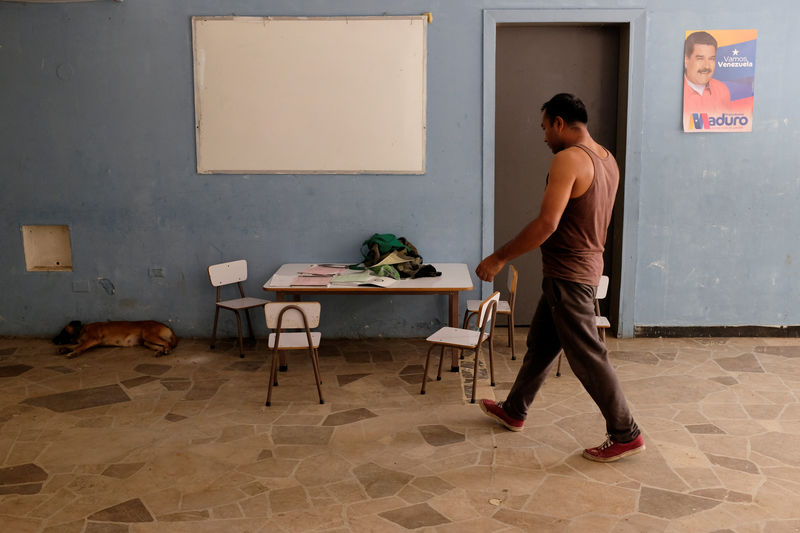 © Reuters. A man walks inside a house occupied by the Apacuana commune in Caracas