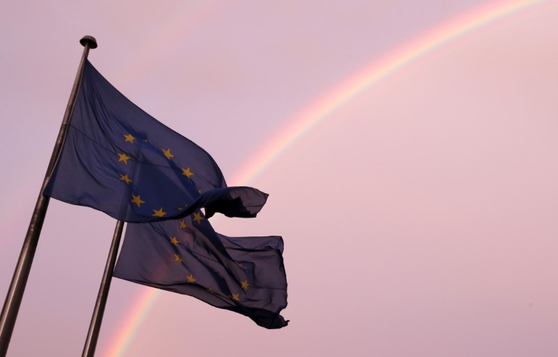 © Reuters. FILE PHOTO: A rainbow is seen near European flags fluttering outside an emergency euro zone summit in Brussels
