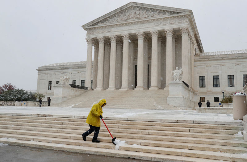© Reuters. A worker clears snow from the steps outside of the U.S. Supreme Court in Washington